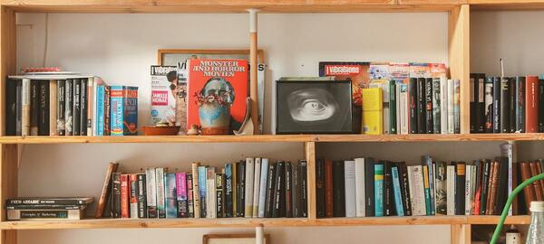 Rolled yoga mat with a plant nearby on a wooden floor